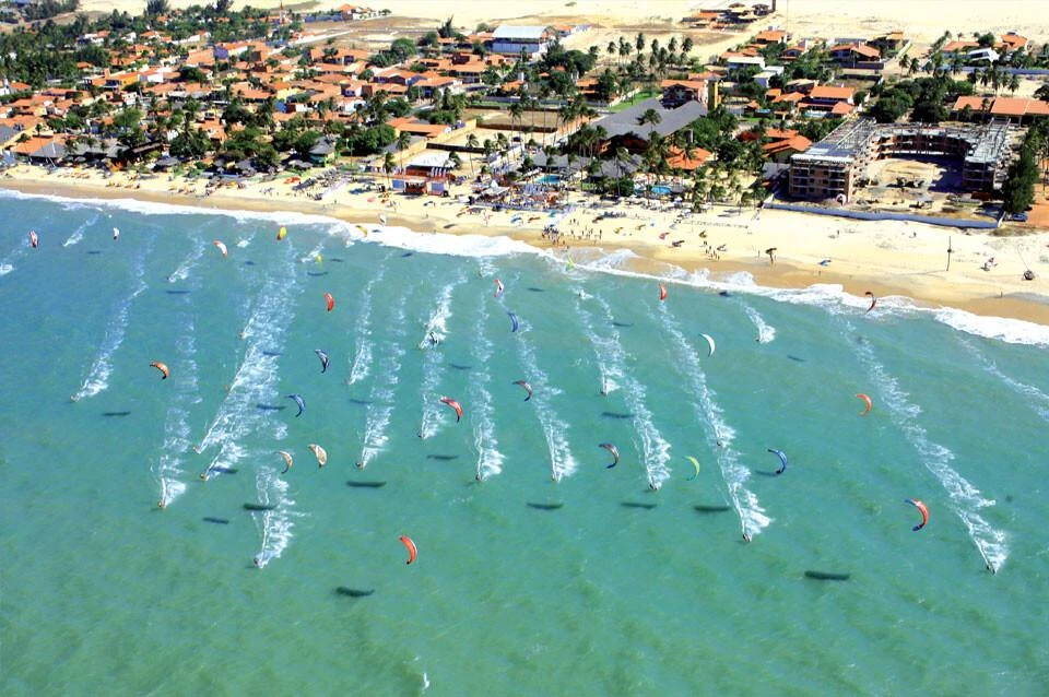 Fotografia real de kitesurfistas e suas velas coloridas no mar de Cumbuco